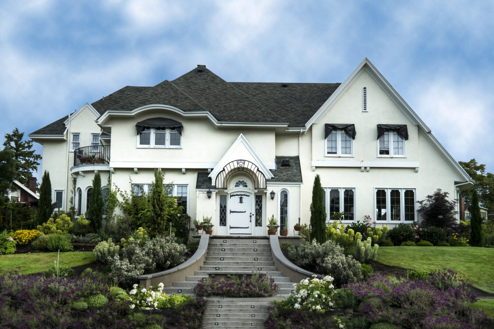Exterior of white stucco luxury house with landscaped yard